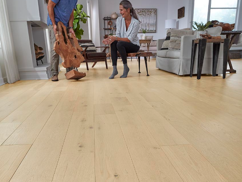 A man and woman select organic wood decor to accent their Mohawk hardwood floors in a natural blonde wood tone.